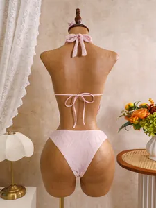 Detailansicht der Rückseite eines rosa strukturierten Bikinis auf einer Schaufensterpuppe