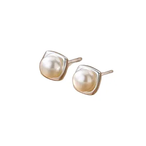 Elegant pearl stud earrings with a minimalist square metal frame, French luxury style.