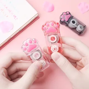 Detailed close-up of a cute cat paw shaped correction tape in a clear pink glitter finish