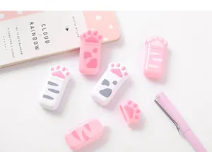 Detailed view of pink and white cat paw shaped correction tapes on desk