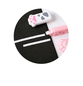 Close-up detail showing the cute cat paw shaped correction tape on a dark background