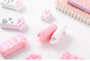 Close-up detail of cute cat paw shaped correction tapes in pink and white school stationery.