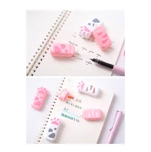 Detail shot of cute cat paw shaped correction tapes on a notebook with a pink pen.
