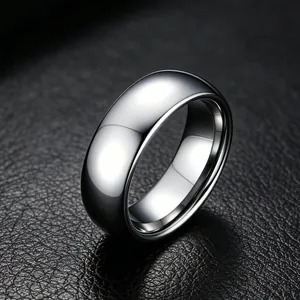 Close-up of polished 316L stainless steel band ring on black leather background