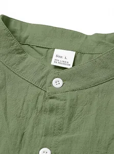 Detailansicht eines grünen Leinen-Henley-Hemdkragens mit Knöpfen und Materialetikett
