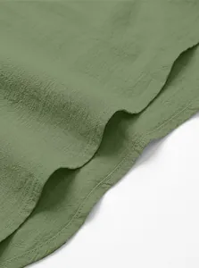 Makroaufnahme der Textur eines grünen Baumwoll-Leinen-Hemdes und der Saumnähte.