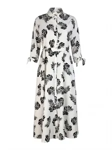 Detailed view of white maxi shirt dress with black leaf print and belted waist