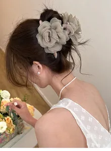 Vue détaillée d'une élégante pince à cheveux rose en tulle sur un chignon féminin