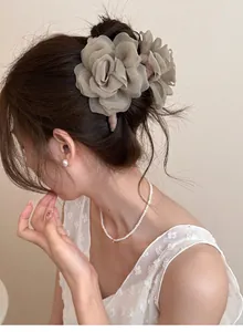 Détail d'une grande pince à cheveux rose en résille beige sur une coiffure élégante