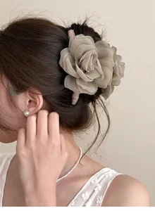 Gros plan d'une pince à cheveux élégante en forme de rose en résille sur un chignon