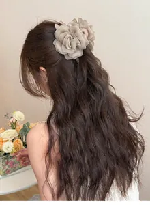 Vue détaillée d'une pince à cheveux rose en tulle beige sur cheveux bruns