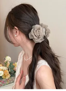 Vue détaillée d'une élégante pince à cheveux rose en tulle sur les cheveux du modèle