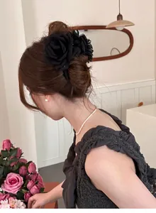 Vue arrière d'une élégante pince à cheveux en tulle rose noire fixée sur un chignon