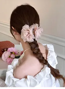 Pince à cheveux élégante en forme de rose en résille sur une tresse vue de dos