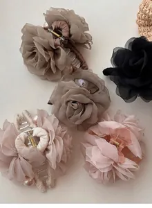 Vue détaillée des élégantes pinces à cheveux en rose de tulle avec perles décoratives