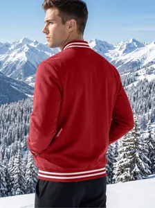 Back view of a red men's varsity jacket with white striped collar in snowy mountains
