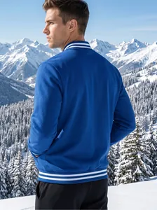Rear view of a men's blue varsity jacket with white stripes in a snowy mountain setting