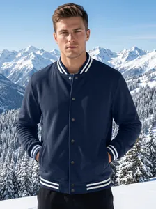 Front view of navy blue varsity jacket with white stripes on a model in snow mountains