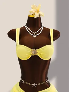 Vue détaillée de face d'un bikini jaune en nylon avec des ornements dorés en forme de soleil.
