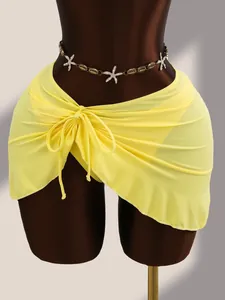 Vue détaillée d'un paréo de plage jaune avec nœud sur le côté sur un mannequin de couture