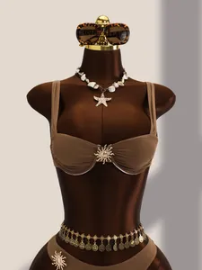 Détail rapproché d'un bikini en nylon marron avec des ornements en métal doré en forme de soleil.