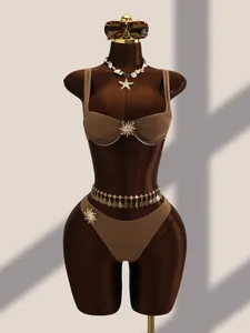 Élégant maillot de bain bikini marron deux pièces avec breloques soleil dorées sur mannequin