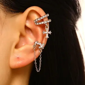 Close-up of elegant silver-tone zircon cross ear cuff and chain earring set detail
