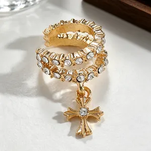 Detailed close-up of elegant gold-plated zircon cross ear cuff with hanging charm