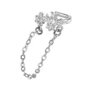Detailed close-up of a silver cross ear cuff featuring cubic zirconia and a dangling chain.