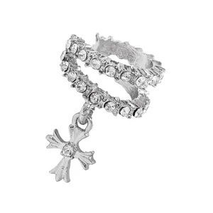 Close-up of elegant silver copper ear cuff featuring cubic zirconia and cross charm
