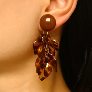 Detailed macro view of Maillard style leopard print petal tassel earrings on model ear