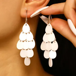 Détail en gros plan d'élégantes boucles d'oreilles à glands en pétale d'acrylique blanc