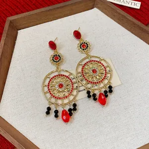 Gros plan de boucles d'oreilles ethniques rétro avec strass rouges et perles noires