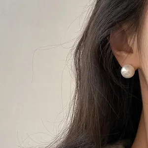 Elegant S925 silver needle pearl stud earrings with a lustrous finish on an Asian model