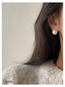 Close-up detail showing a 12mm elegant round pearl stud earring with soft luster worn on ear