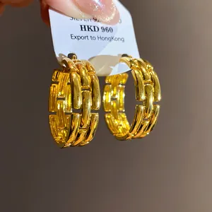 Detailed macro view of chunky gold-plated chain link hoop earrings for luxury style