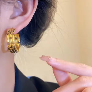 Chunky gold-plated chain-link hoop earrings worn on ear for elegant fashion style