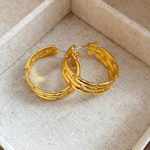Detail of gold-plated hoop earrings with elegant geometric link design