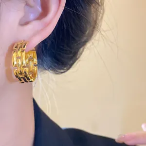 Detailed view of an elegant gold-plated hoop earring featuring a sophisticated link pattern
