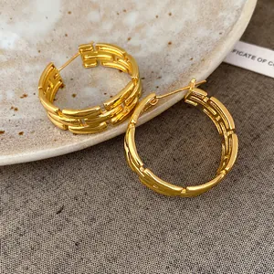 Macro view of luxury gold-plated hoop earrings featuring a unique textured link design