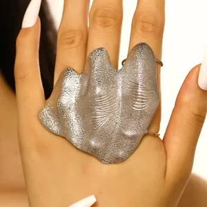 Detailed view of artistic silver irregular pleated knuckle ring with textured finish