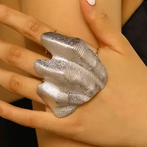 Close-up detail of an artistic irregular pleated silver knuckle ring with texture