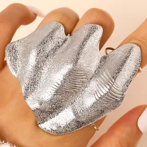 Detail close-up of artistic irregular pleated silver knuckle ring with hammered texture