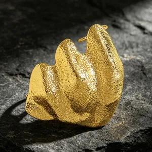 Macro view of artistic irregular pleated gold joint ring with a textured hammered surface