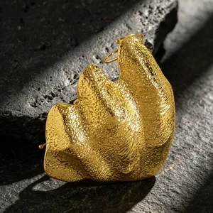 Macro shot showing the textured metallic finish of an artistic irregular gold knuckle ring
