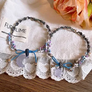 Detailed view of the braided bracelet with resin moon and star pendants and bead charms.