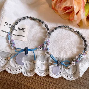 Detailed view of woven flower bracelets with star and moon resin charms and blue ribbons.