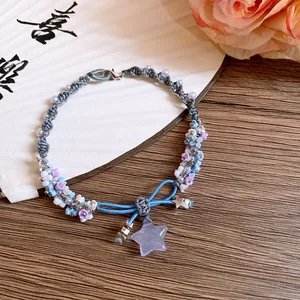 Detailed view of woven resin flower bracelet with purple star pendant and bow knot