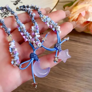 Close-up of resin braided flower bracelets with purple moon and star charms