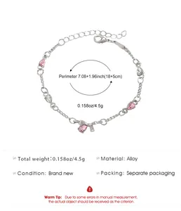 Detail of silver alloy bracelet featuring pink teardrop stones and dainty bow charm